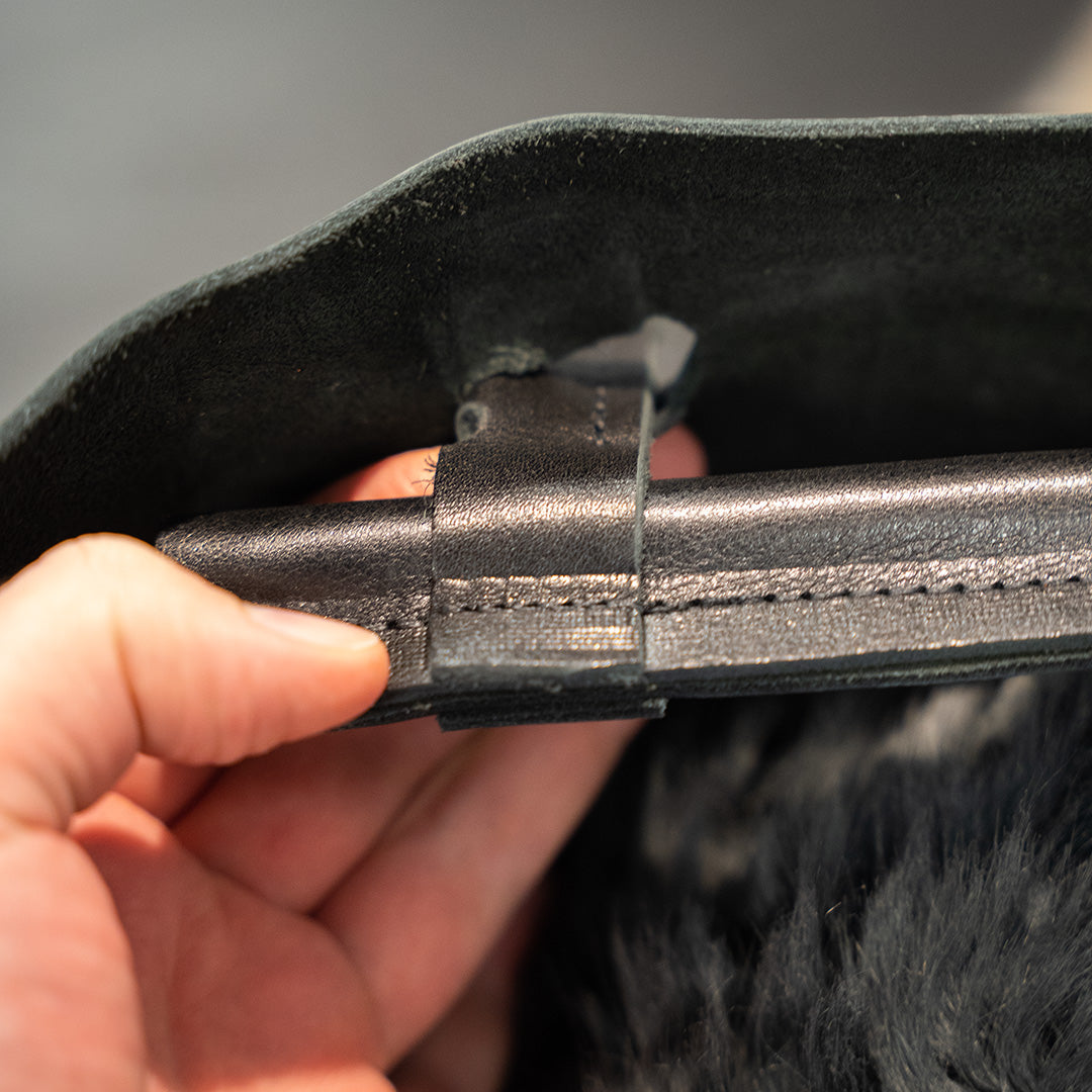 schwarzer Steg hält den Taschenriemen
